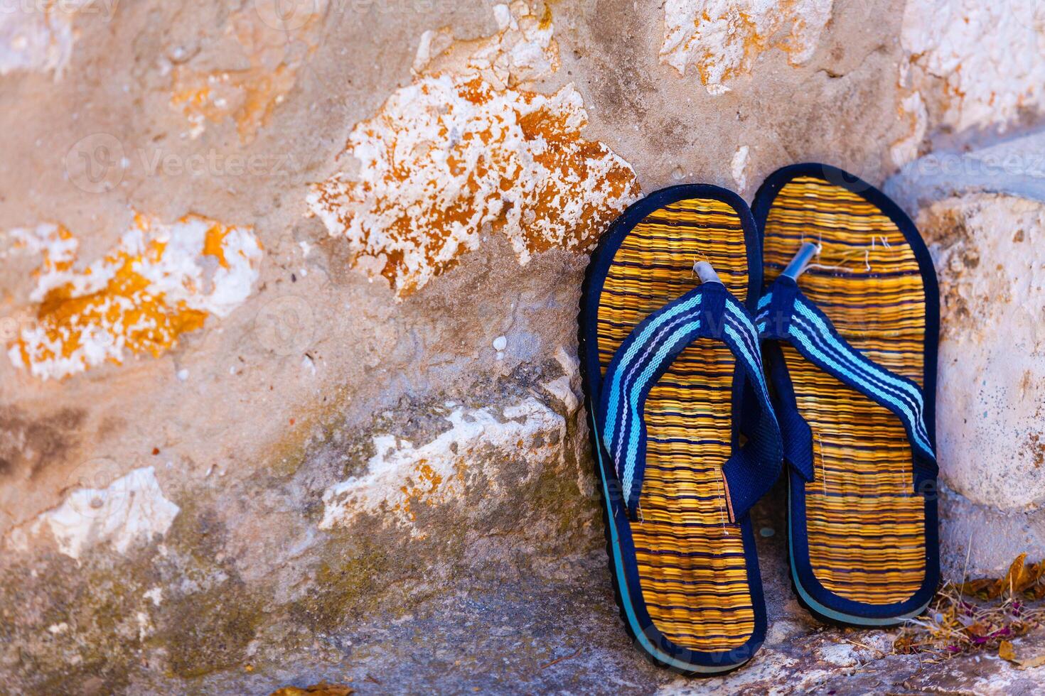 Beach flip-flops on the old wall background photo