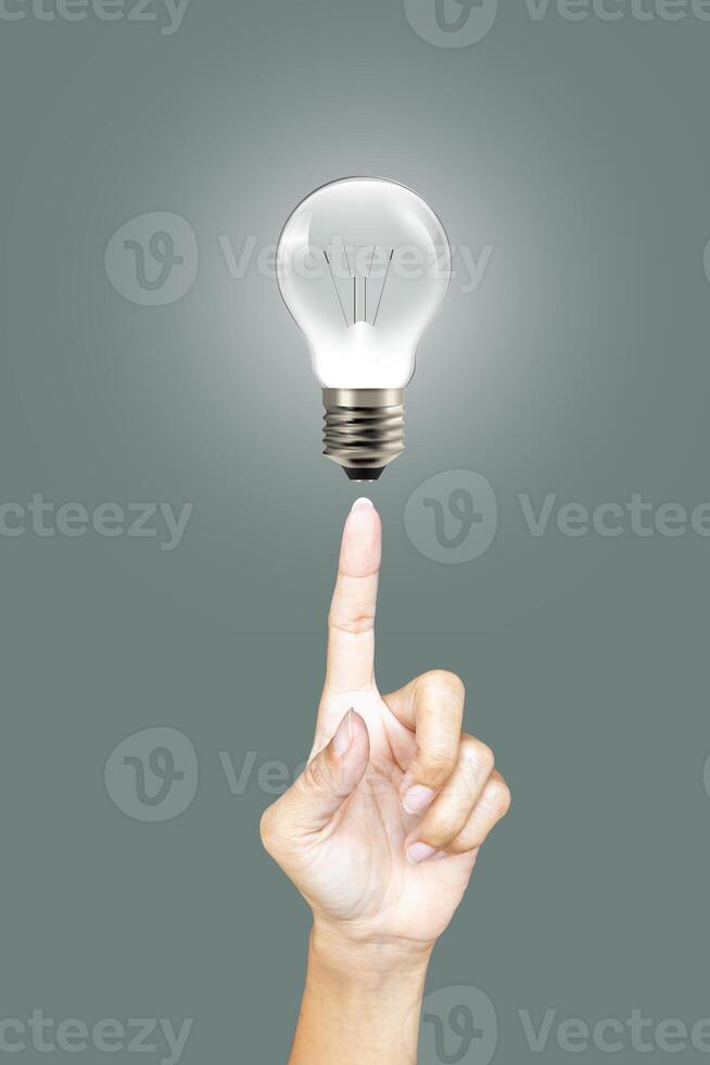 Finger pointing at an illuminated bulb, idea concept photo