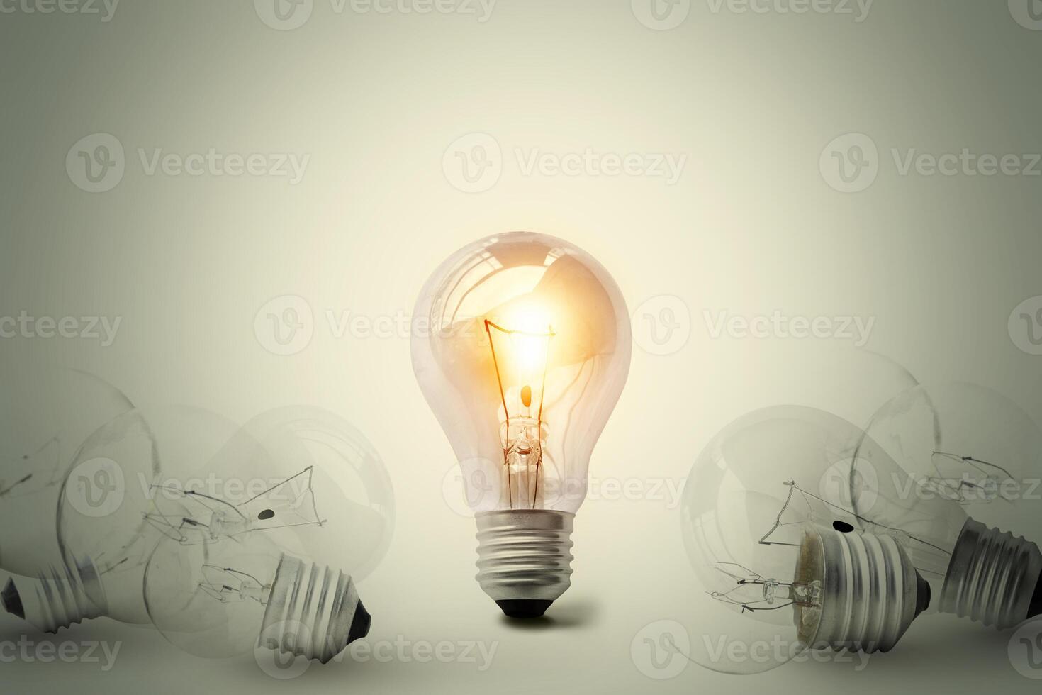 One shining light bulb in the middle between many light bulb. Conceptual different thinking or leadership. photo
