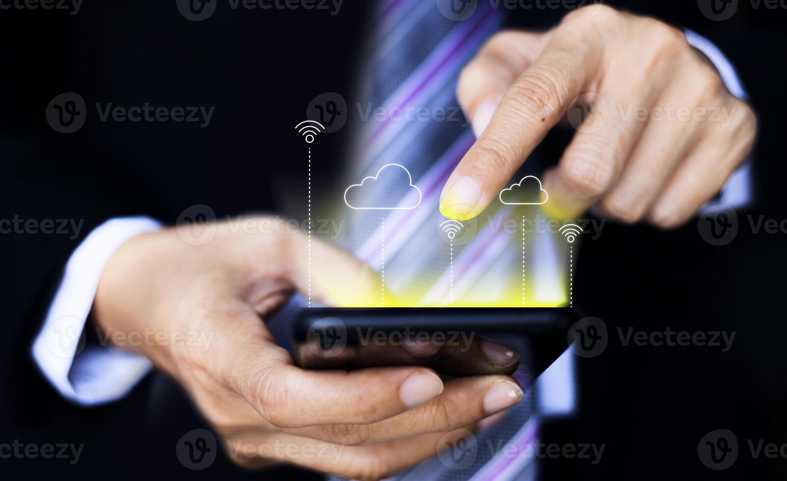 a man in a suit is holding a smartphone with a cloud icon on it photo