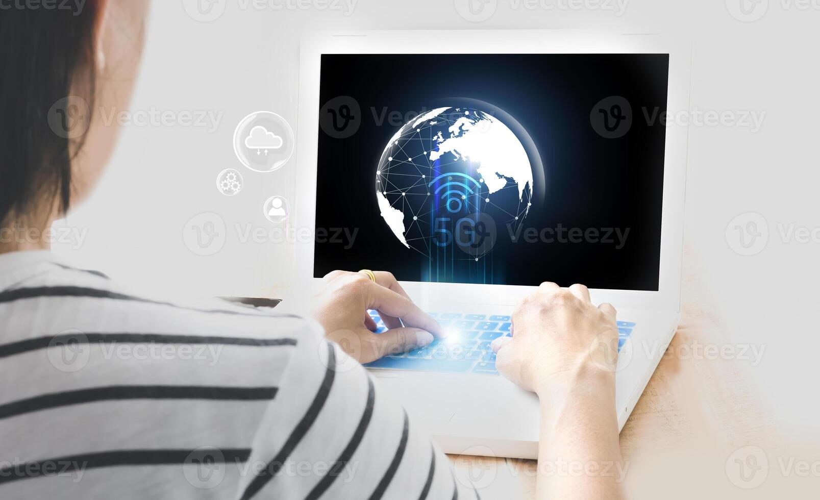 a woman is using a laptop with a globe on it photo