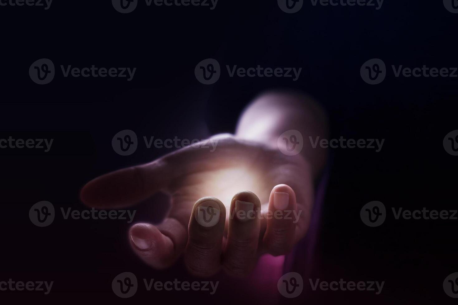 a person holding a glowing light in their hand photo