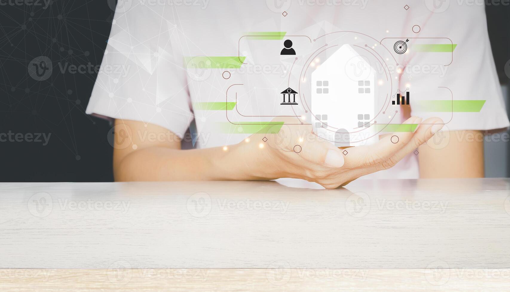 a person holding a house with icons on it photo