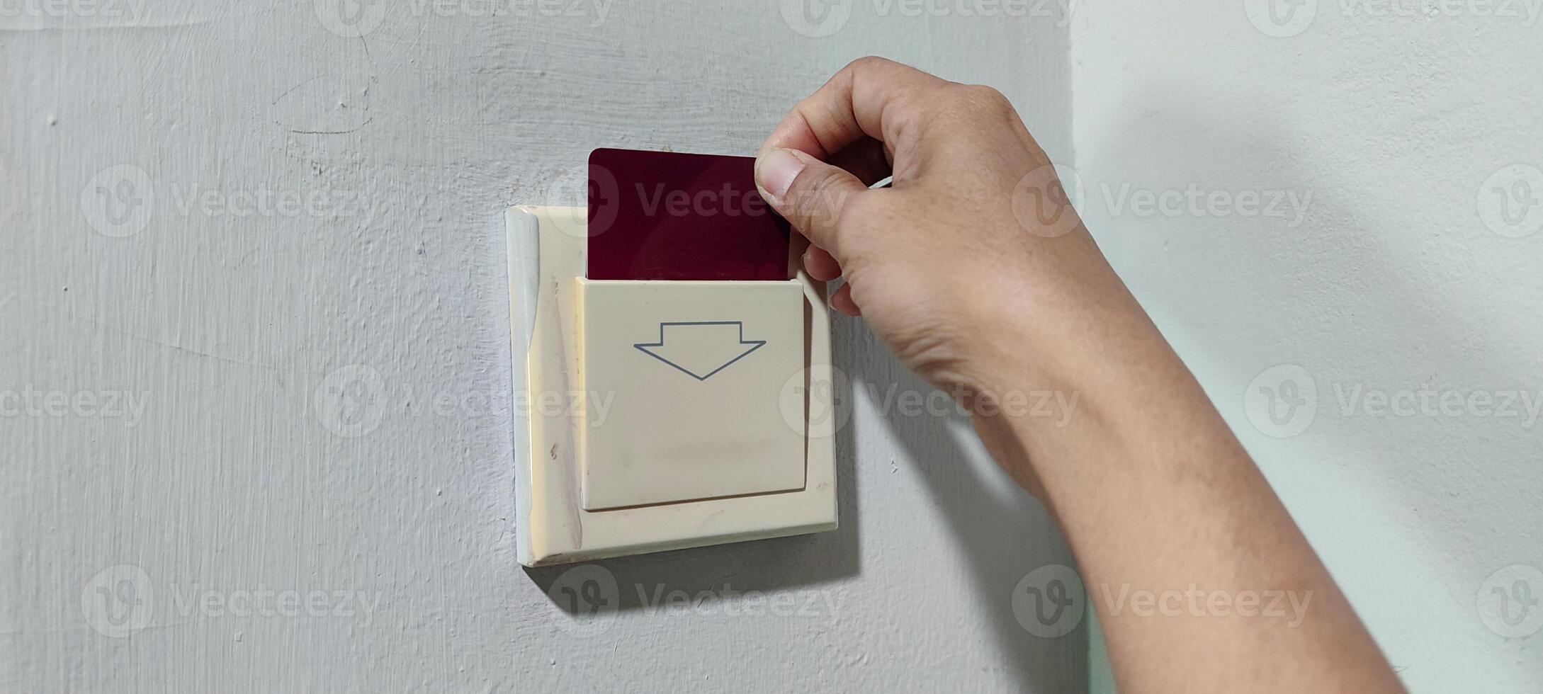 inserting a card key into a switch in a modern hotel room during the day photo