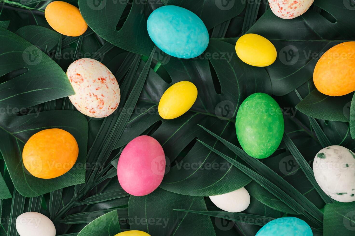 Easter nature background. Green tropical palm and monstera leaves with Easter eggs. Minimal spring abstract jungle or forest composition. Creative festive holiday layout. Flat lay style. photo