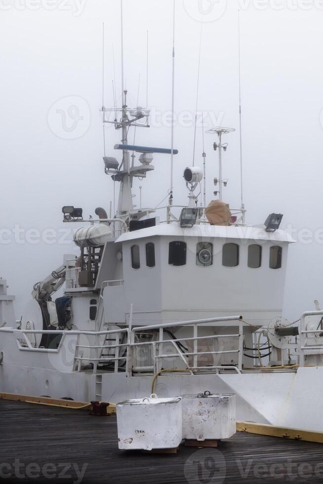 Fishing vessel in a foggy misty morning at Harbor photo