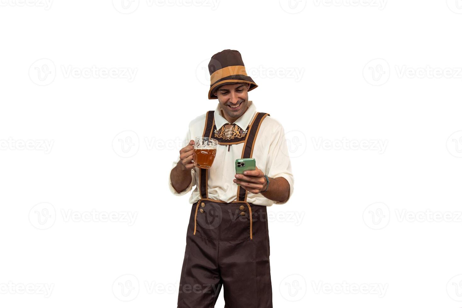 Young bavarian man texting on smartphone while holding beer glass in traditional oktoberfest attire photo