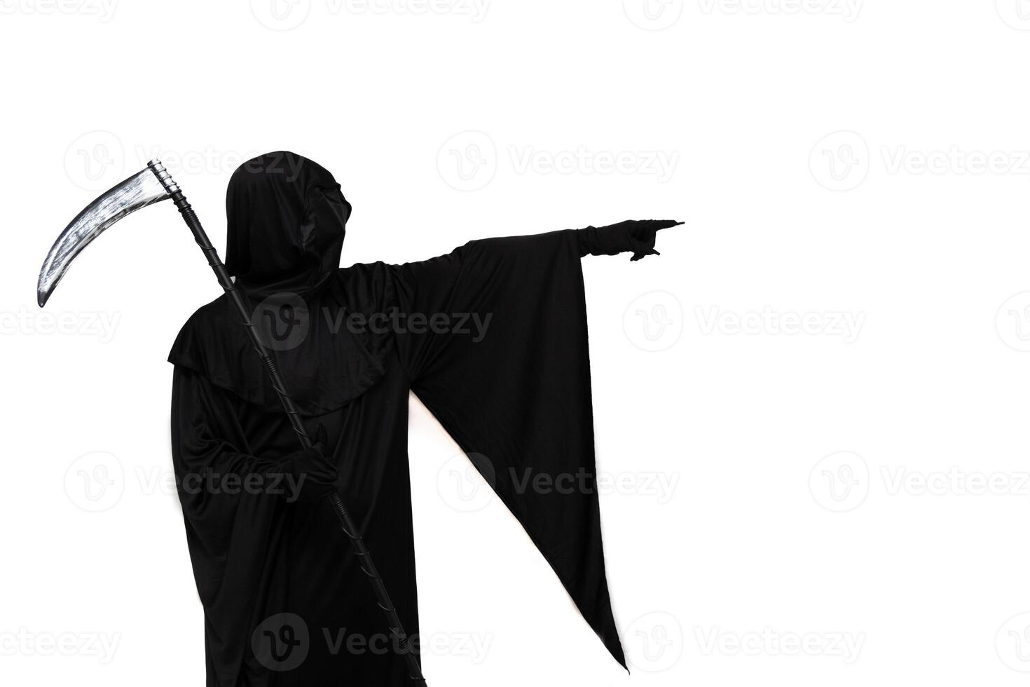 Grim reaper in Halloween costume holding scythe and pointing towards copyspace white background photo