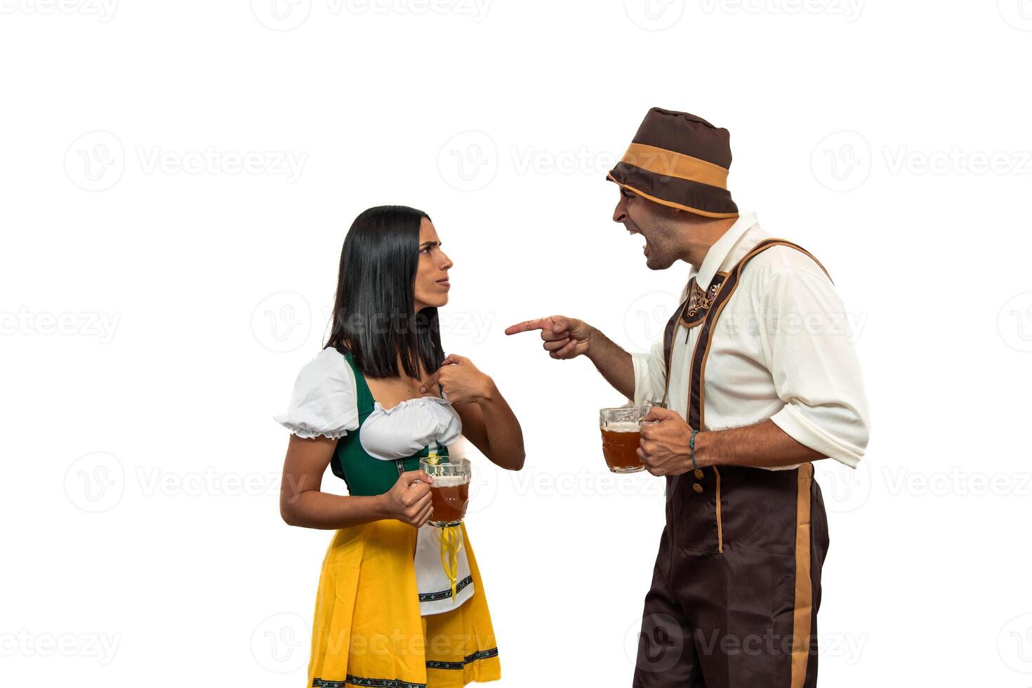 Young bavarian man angrily shouting at girlfriend while holding a beer glass in oktoberfest attire photo
