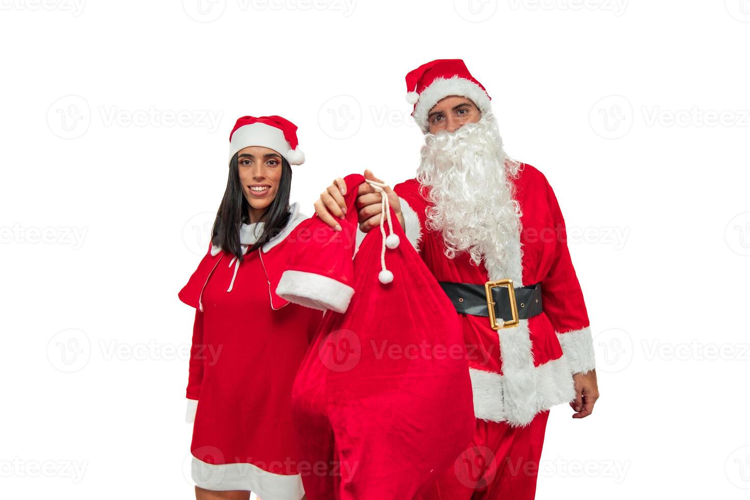 Couple Dressed as Santa Claus Holds a Gift Bag Towards the Camera, Offering It to the Viewer photo
