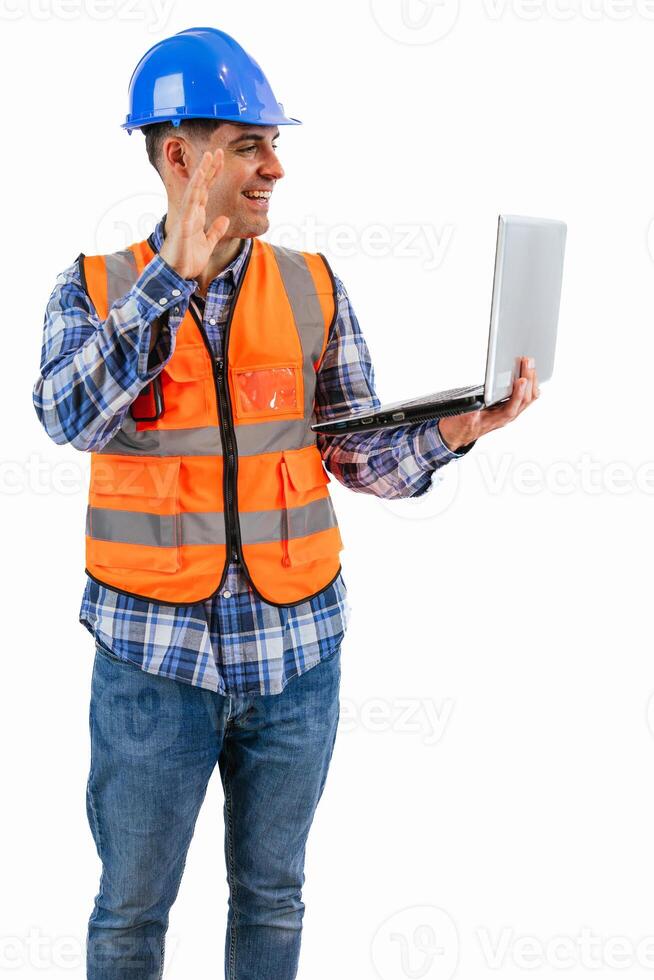 vertical Smiling construction worker making a call with his laptop wearing orange vest photo