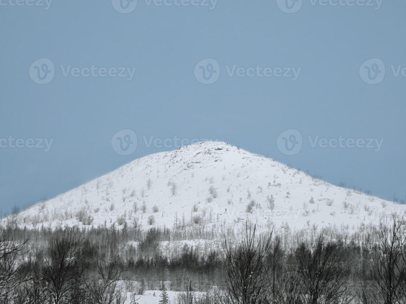 White snow covered the top of the hill on blue sky background. photo