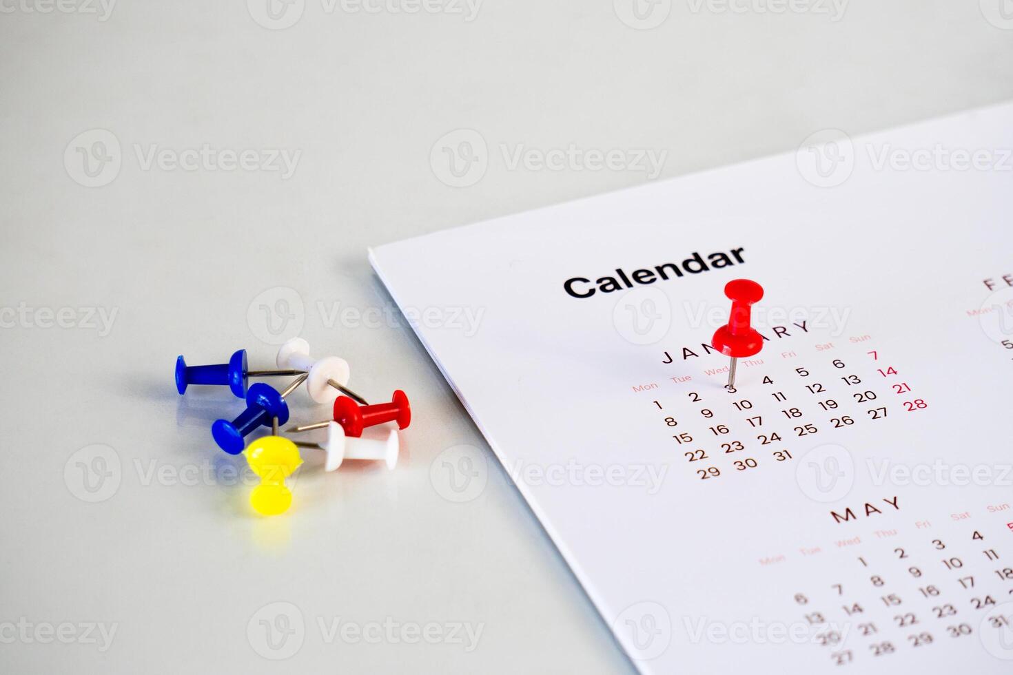red pin stack in calendar on table photo