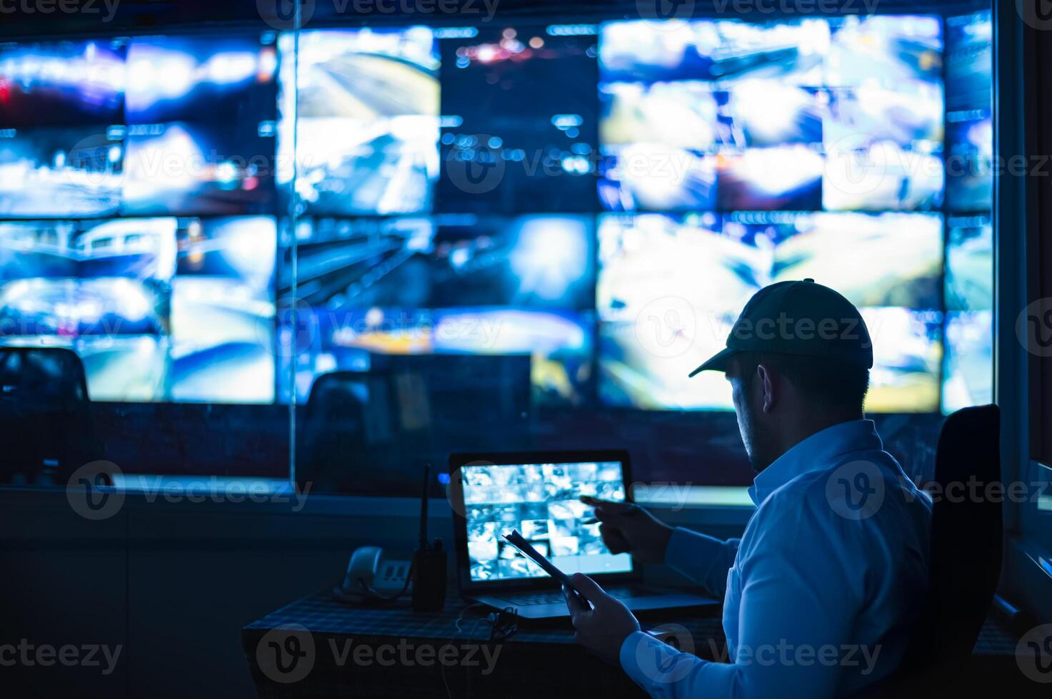 Security guards are monitoring multiple CCTV monitors and reporting on events. photo