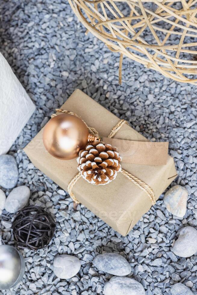 Christmas or New Year composition with gift box, pine cones and decoration on stone background photo