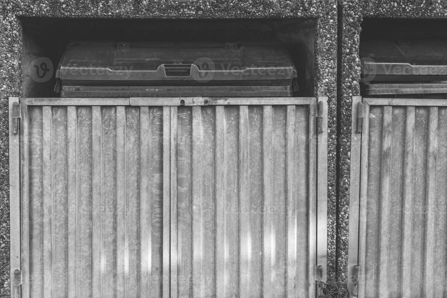 Metal waste bin enclosure with sliding doors at urban location in daylight photo