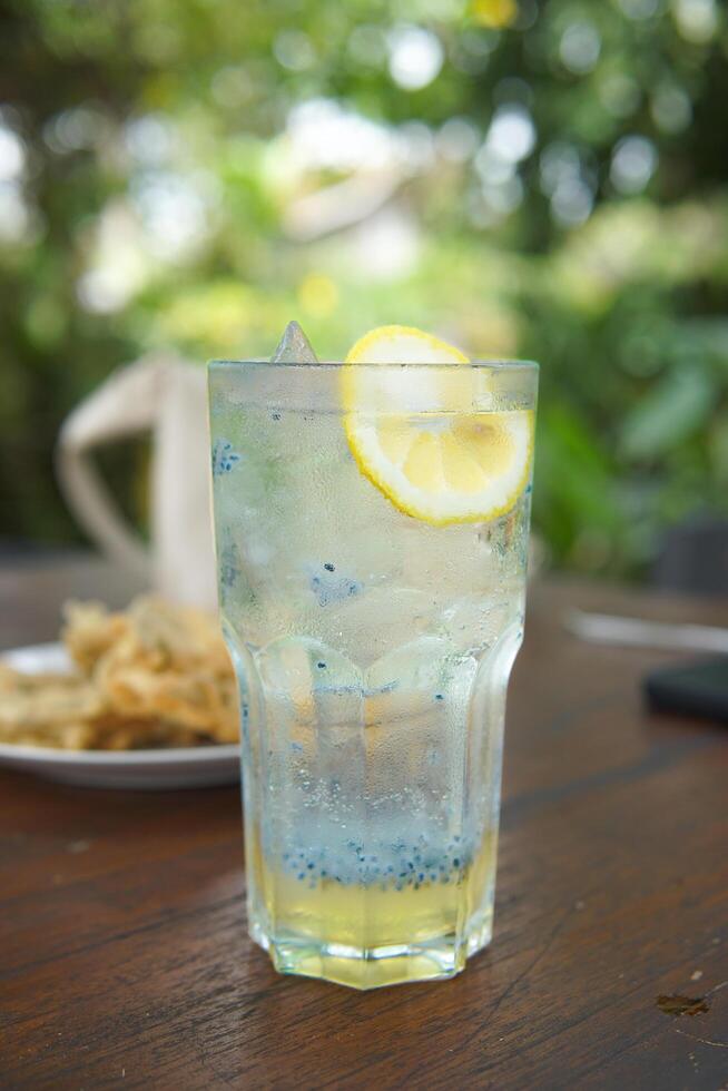 Glass of fresh lemon squash with basil seed drink photo