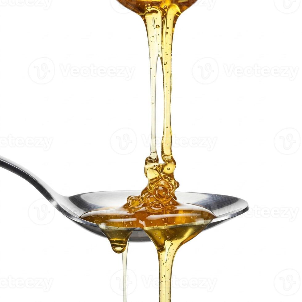 Honey dripping onto a spoon from a honey dipper isolated on white photo