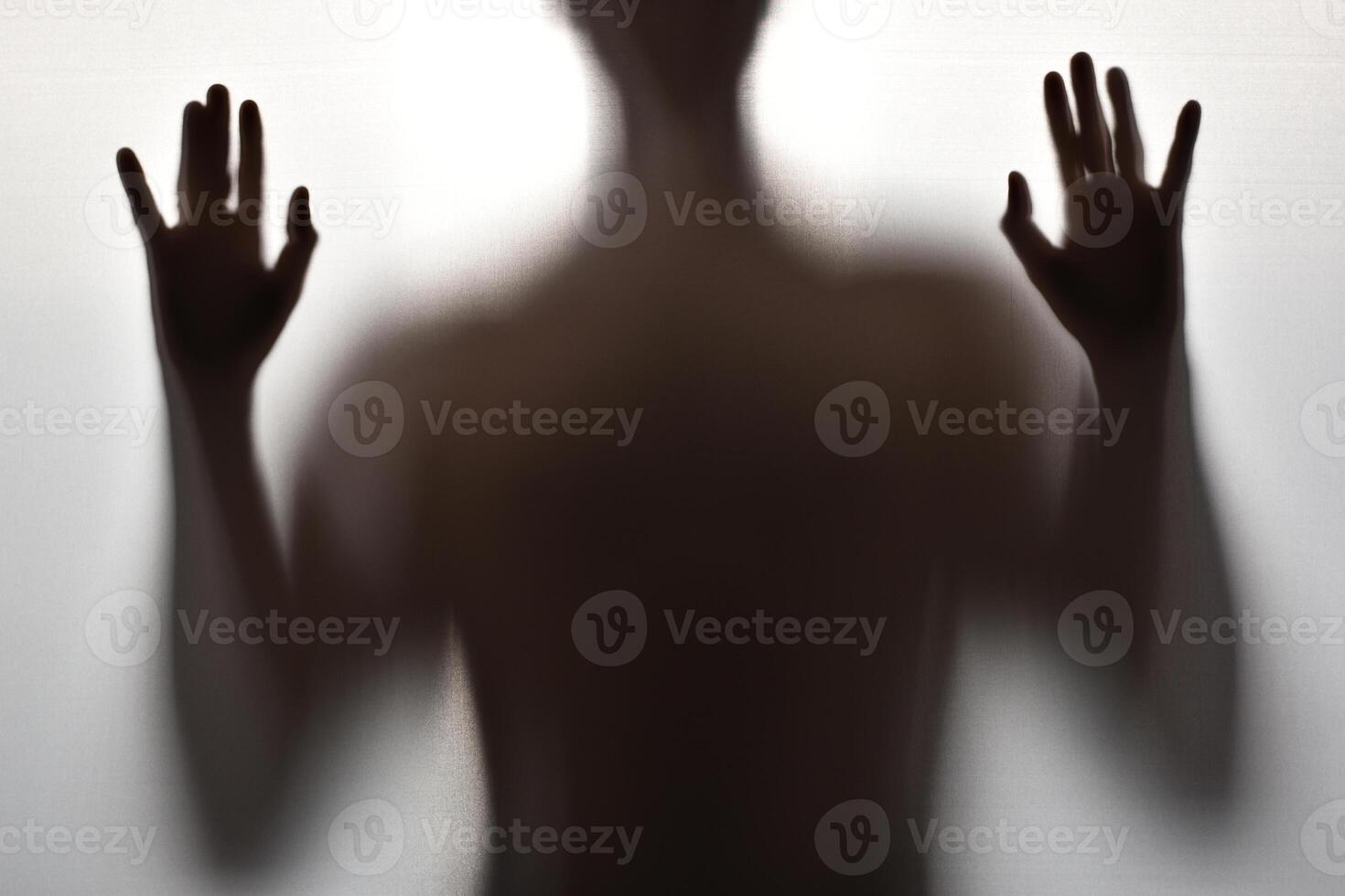 Body of a young man, Creepy shadow of a figure behind a curtain photo