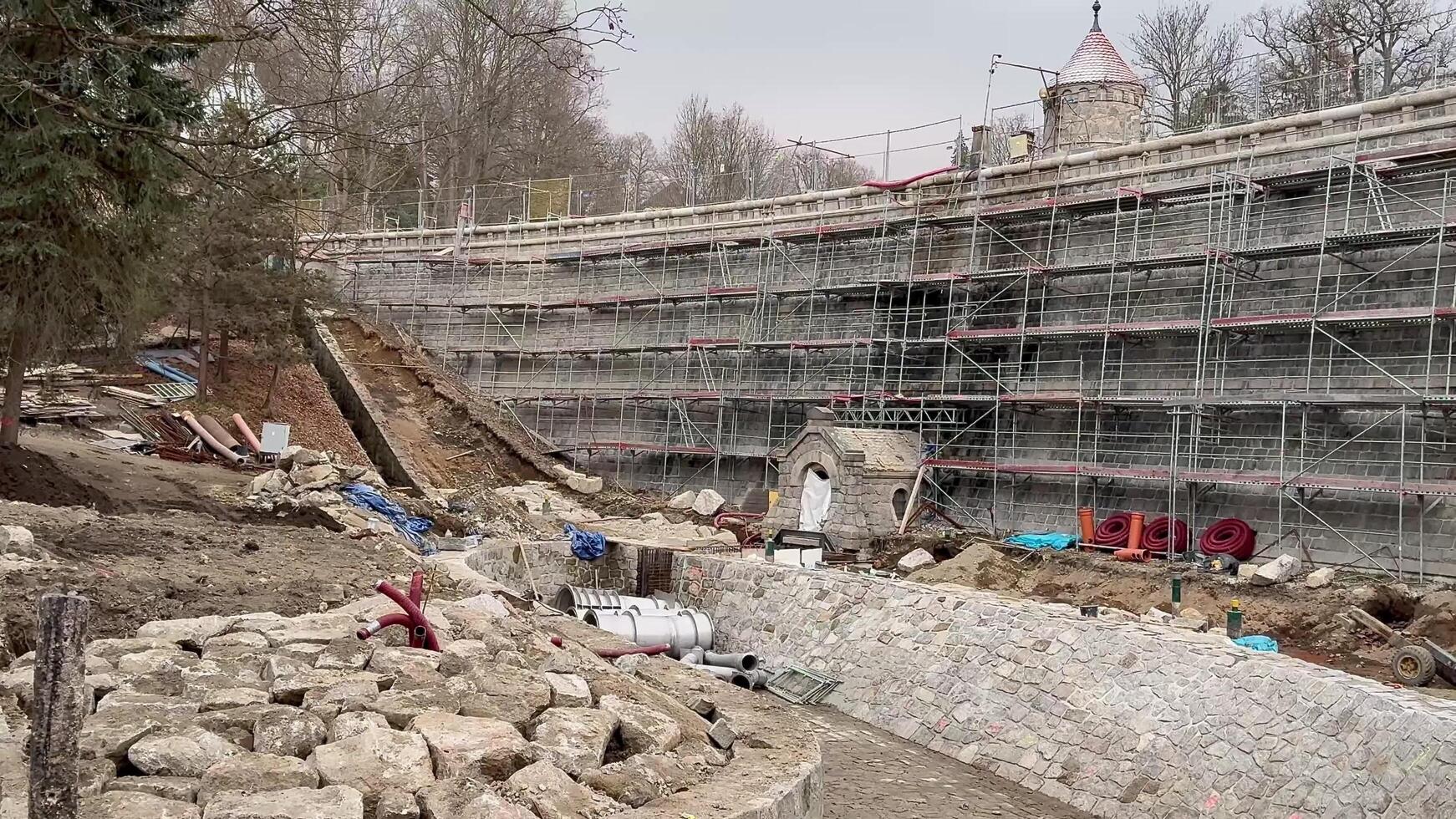 The construction site features scaffolding and ongoing excavation work taking place photo