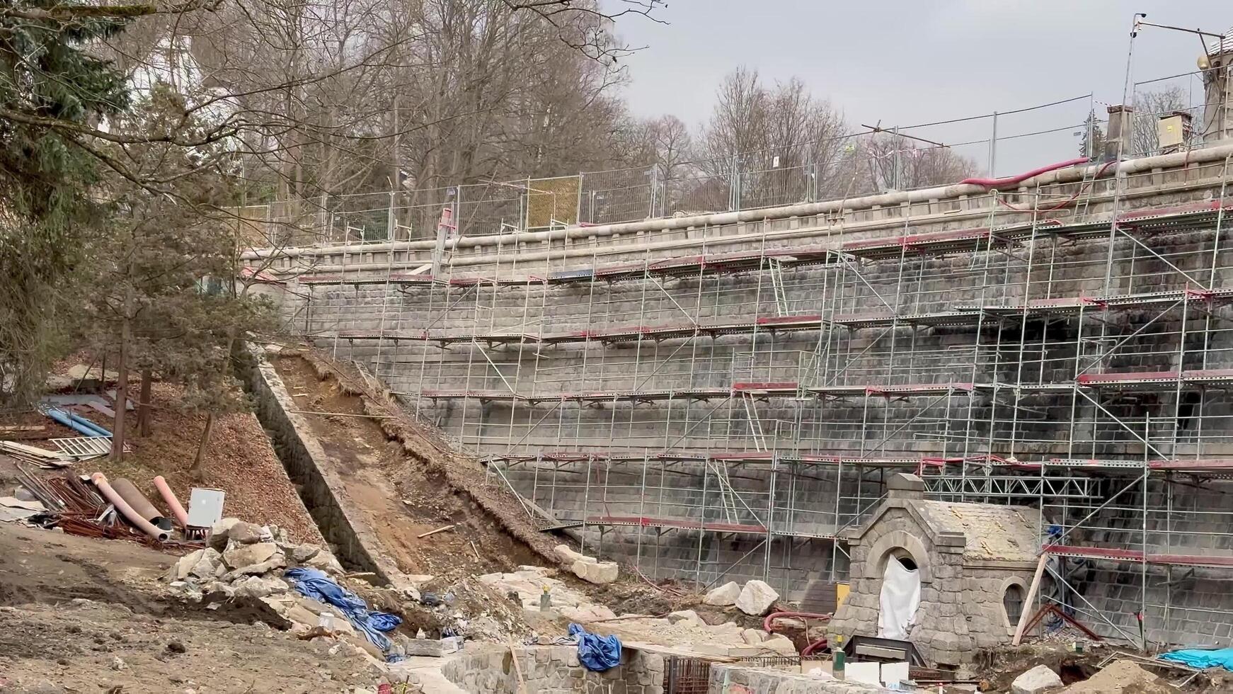 A bustling construction site filled with scaffolding, earthworks, and various activities photo