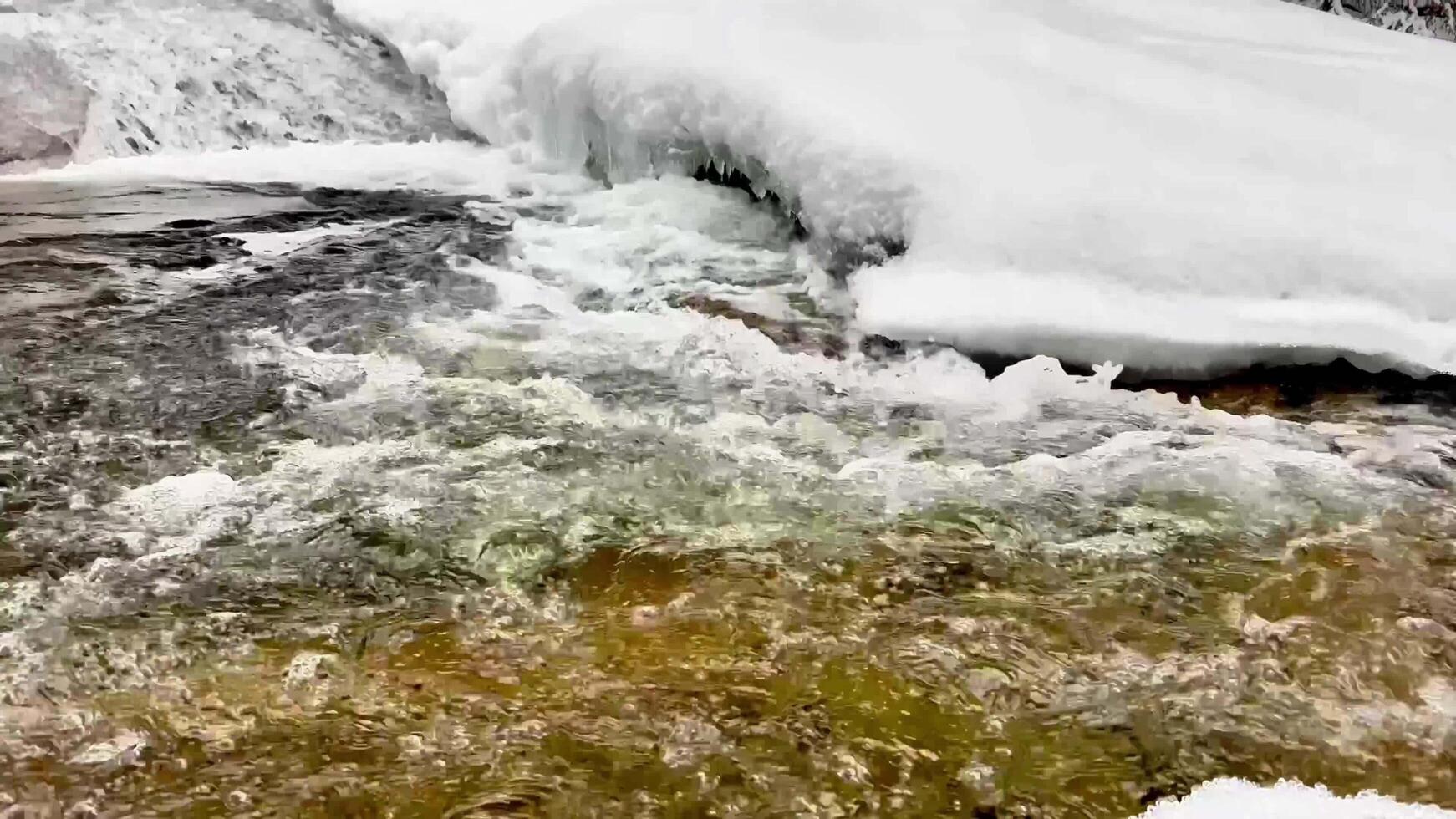 The Gorgeous Process of Melting Snow Above a Flowing and Beautiful Stream in Winter Time photo