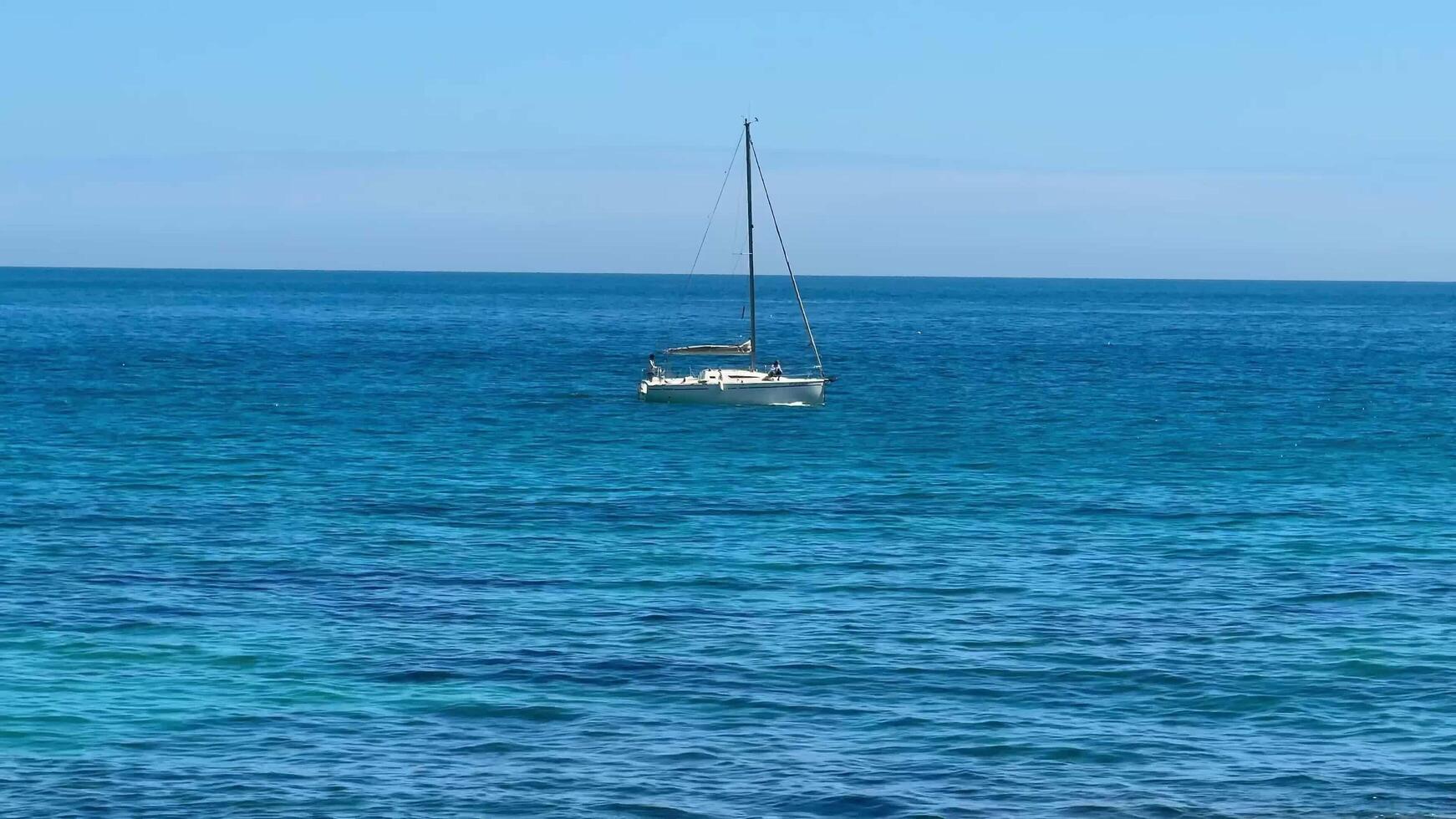A Calm and Serene Ocean Scene Featuring a Beautiful Sailboat Gliding Over Tranquil Waters photo