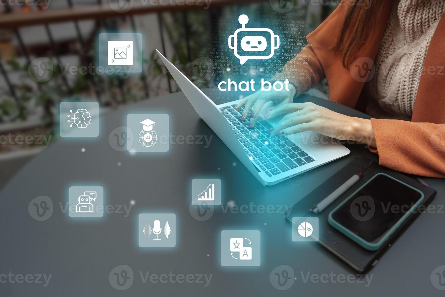 Person using a laptop with chatbot icons and digital graphics in a modern workspace environment photo
