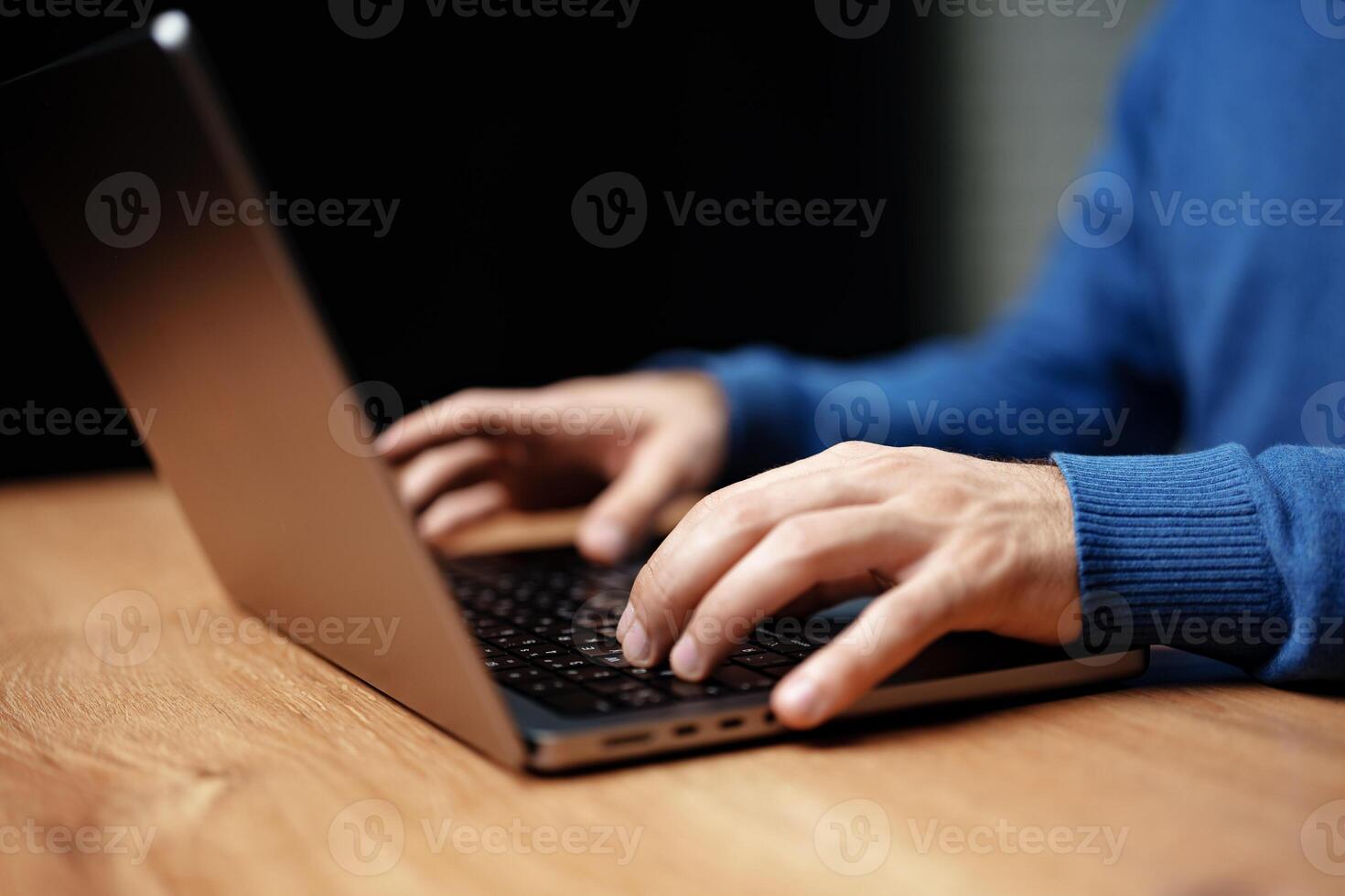 Hands typing on a laptop on a wooden table with a focus on the workspace atmosphere photo