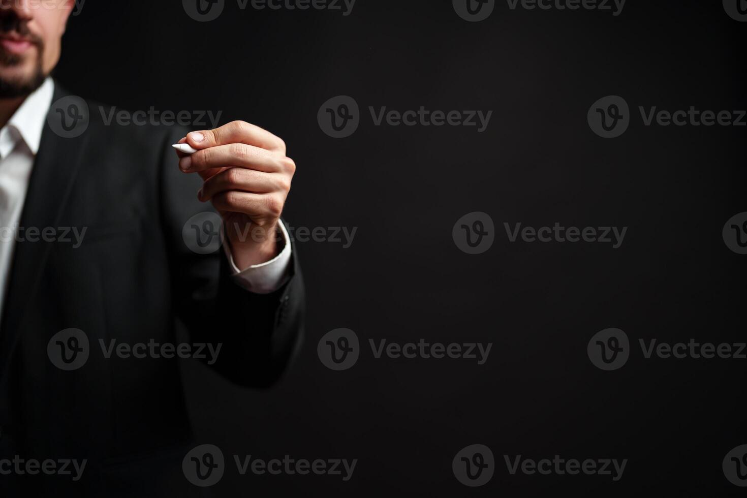 Business professional holds pen in formal attire while preparing for a presentation in an indoor setting at night photo