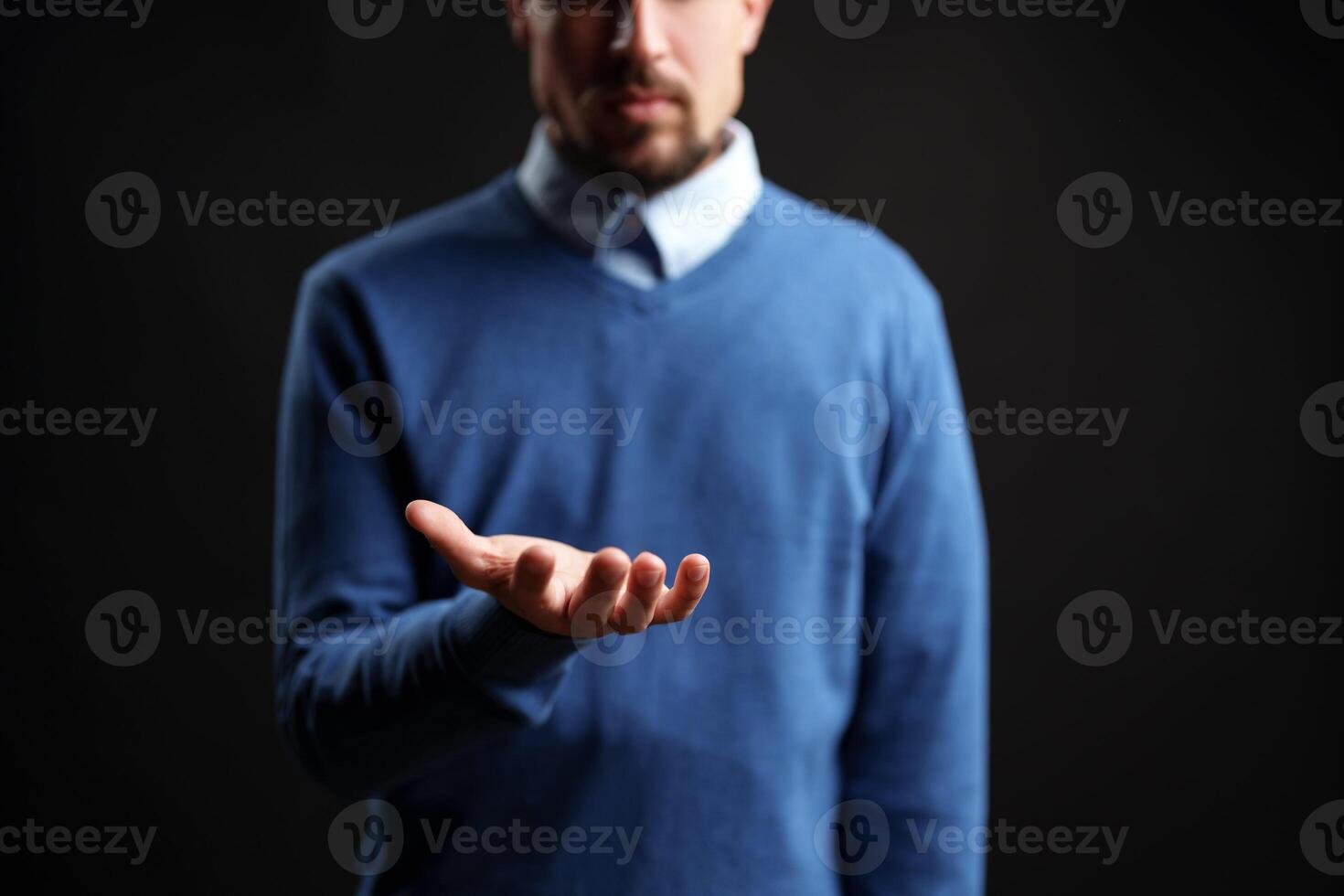 Man reaching out with open hand in a dark setting, conveying invitation or request for assistance photo