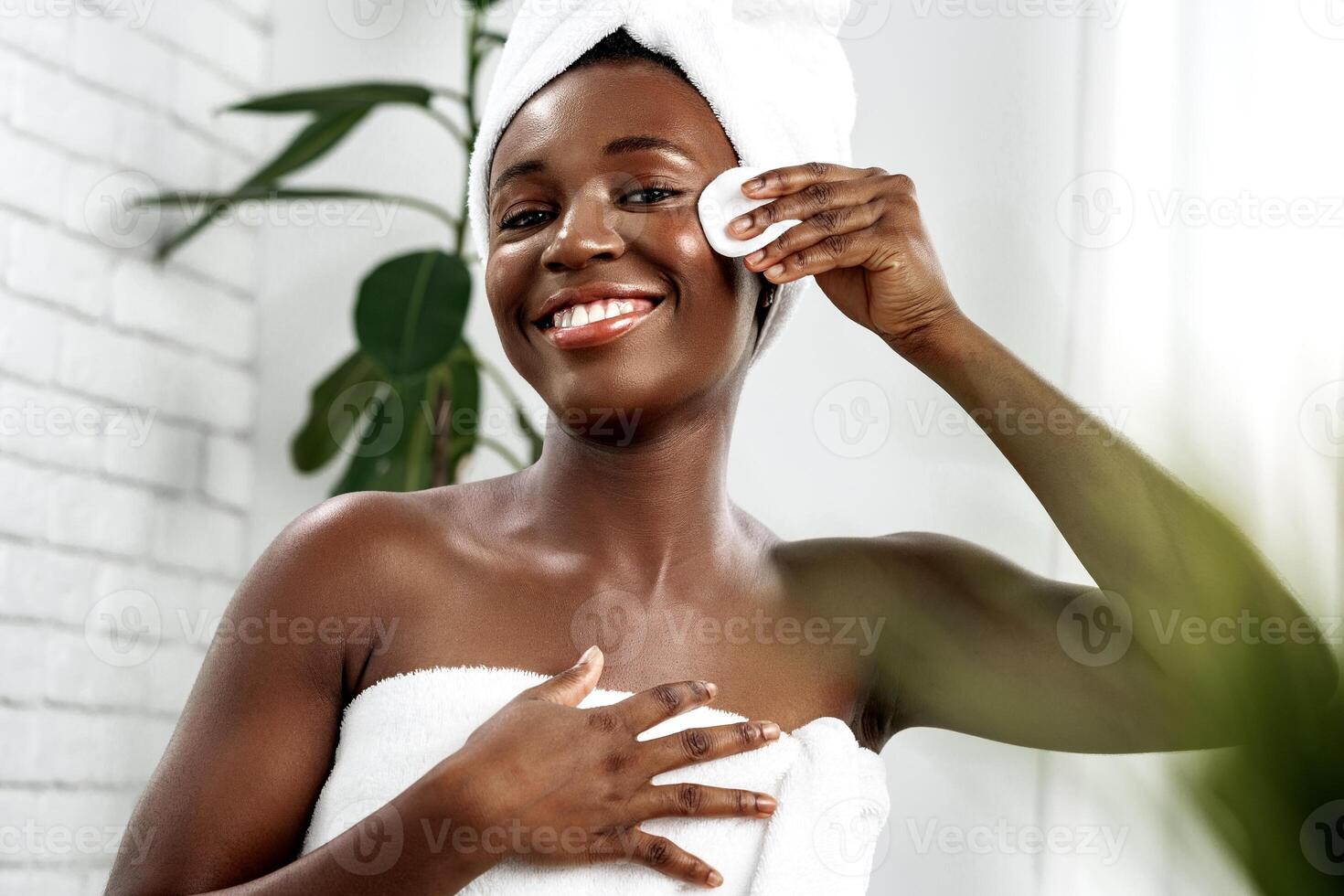 Woman performing skincare routine in a bright and modern bathroom during the day photo