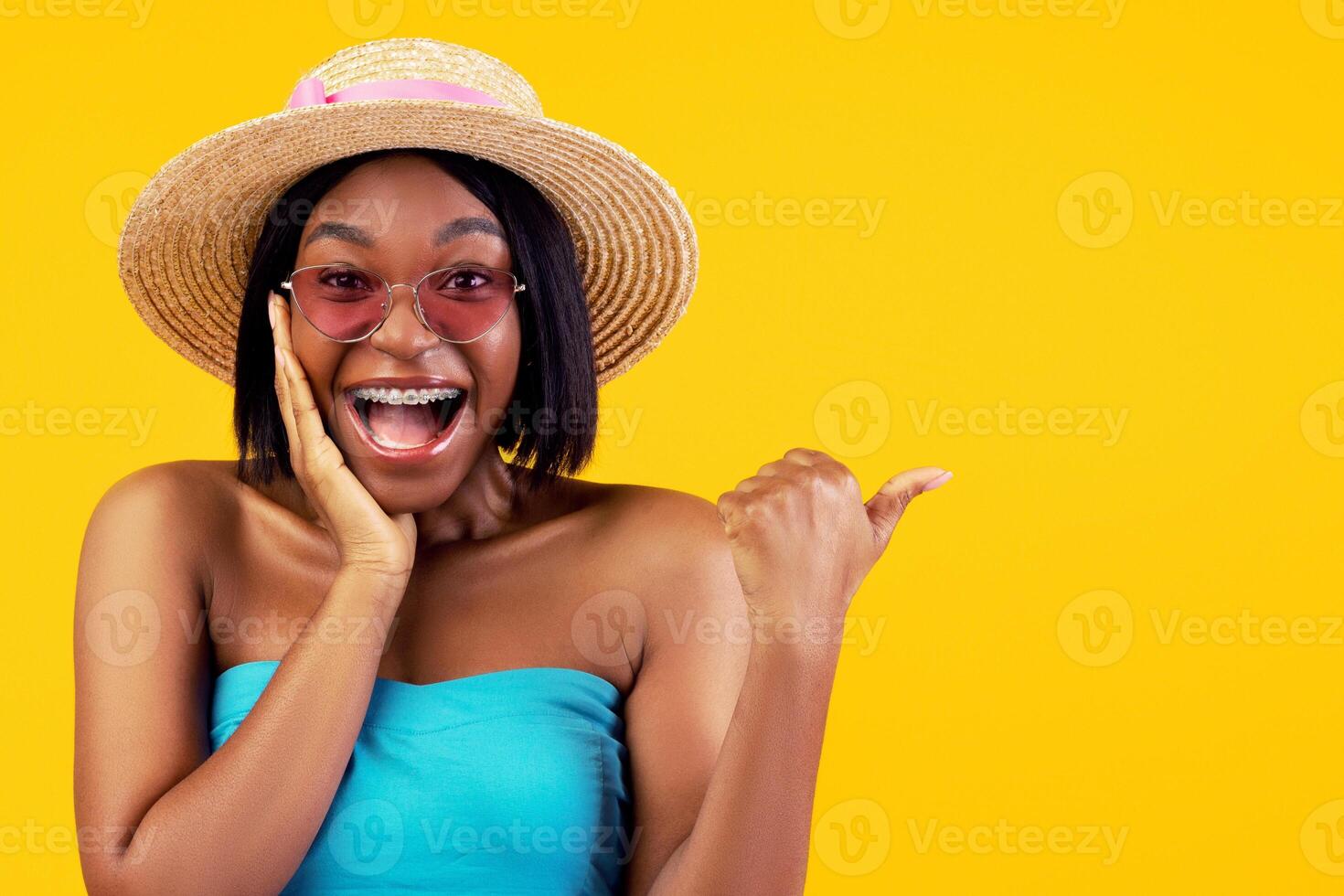 Portrait of excited young black woman in trendy outfit screaming WOW and pointing aside on orange studio background. Unbelievable summer sale, promo, discount concept photo