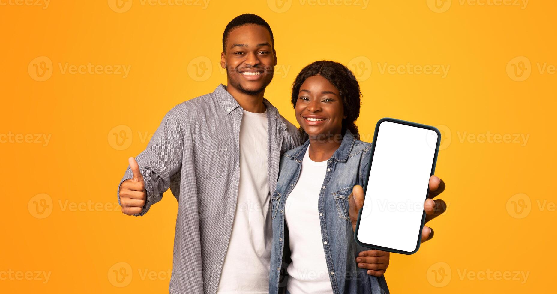 Portrait Of Happy Black Man And Woman Embracing And Showing Thumbs Up At Camera, Cheerful African American Lovers Recommending Something While Standing Isolated Over Yellow Background, Free Space photo