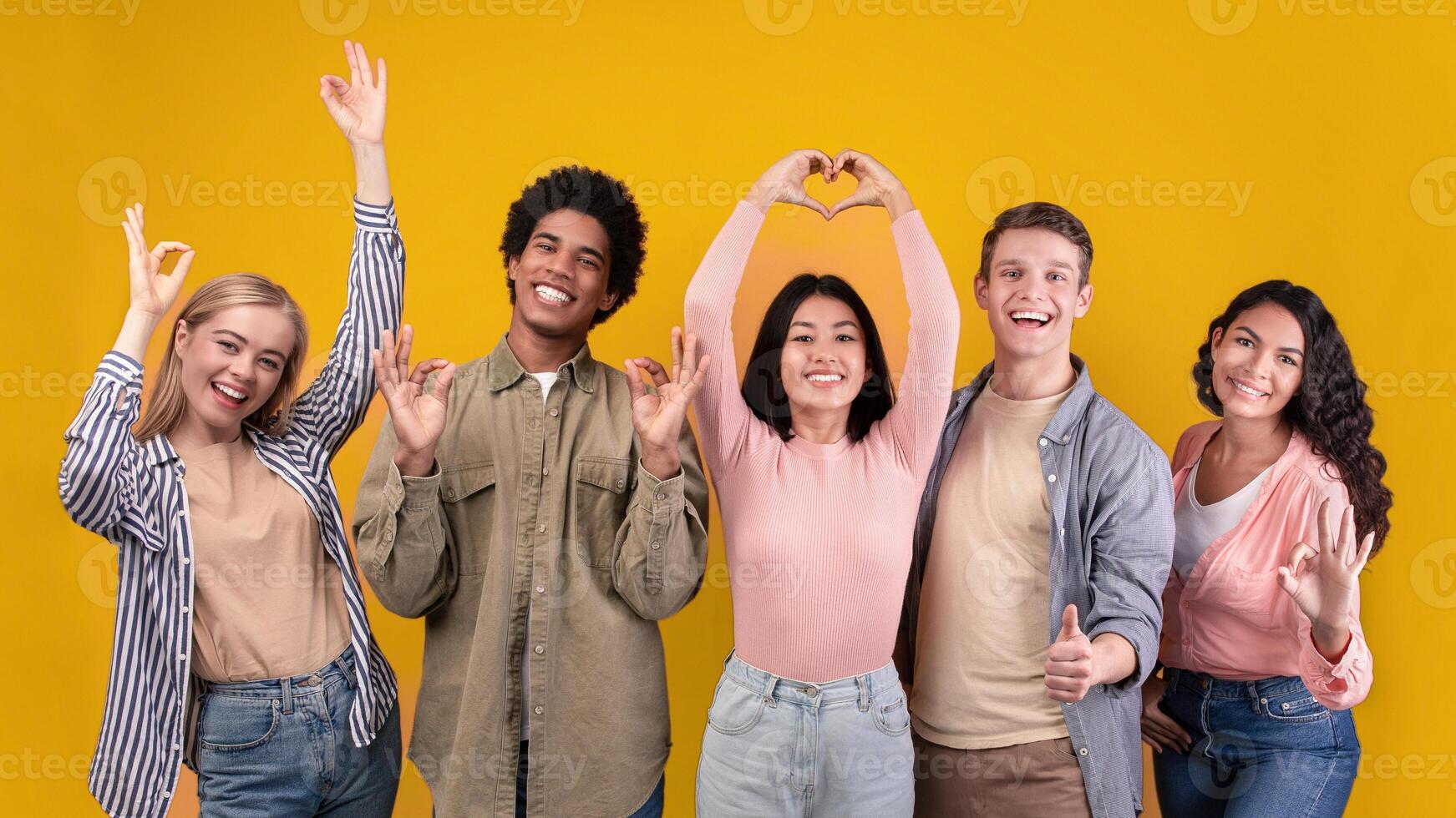 Travel, modern education, study and lifestyle concept. Cheerful young multiracial students teen friends gesturing with hands and have fun, isolated on orange background, copy space, studio shot photo