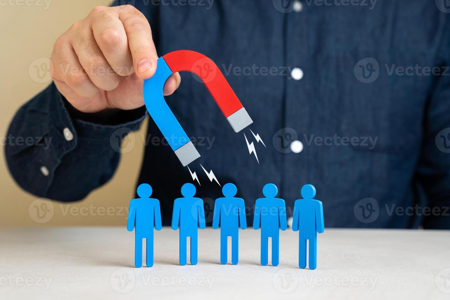 A man with a magnet attracts people. Leadership charisma. Attracting clients or hiring. Recruitment strategies, business outreach, customer acquisition. photo