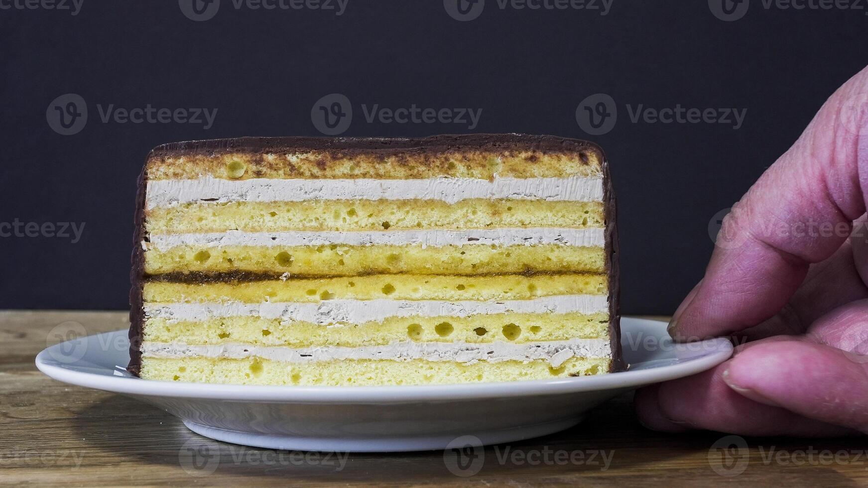 Delicious layered cake with cream and chocolate served on a plate photo