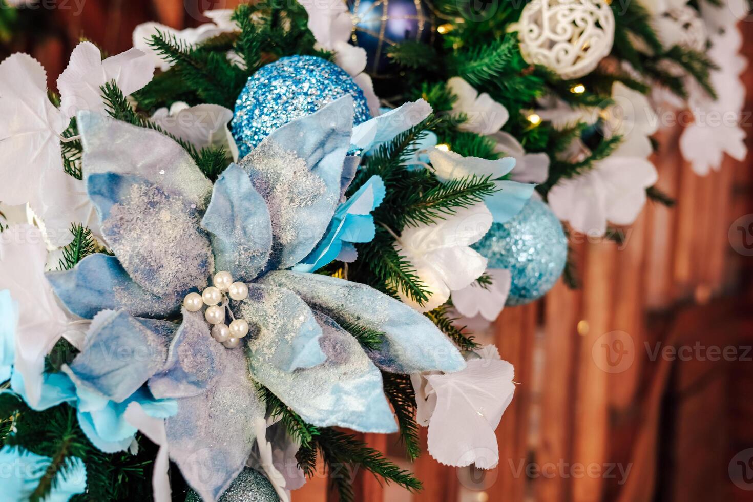 Decorated garland featuring blue flowers and ornaments enhancing holiday ambiance photo