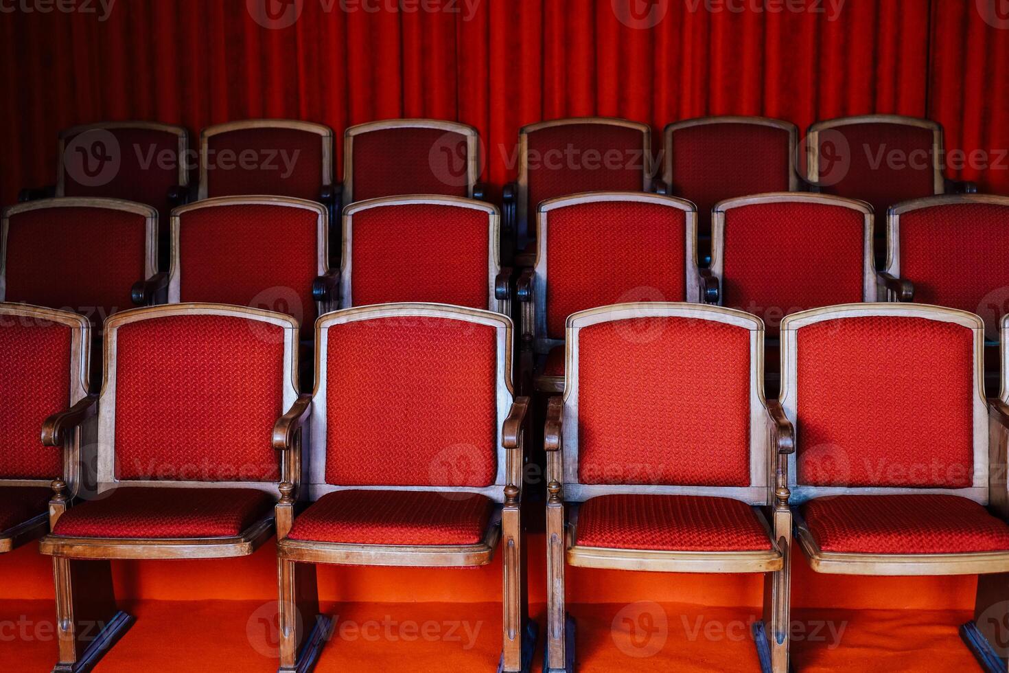 Rows of red upholstered chairs arranged in a theater setting for performance attendees photo