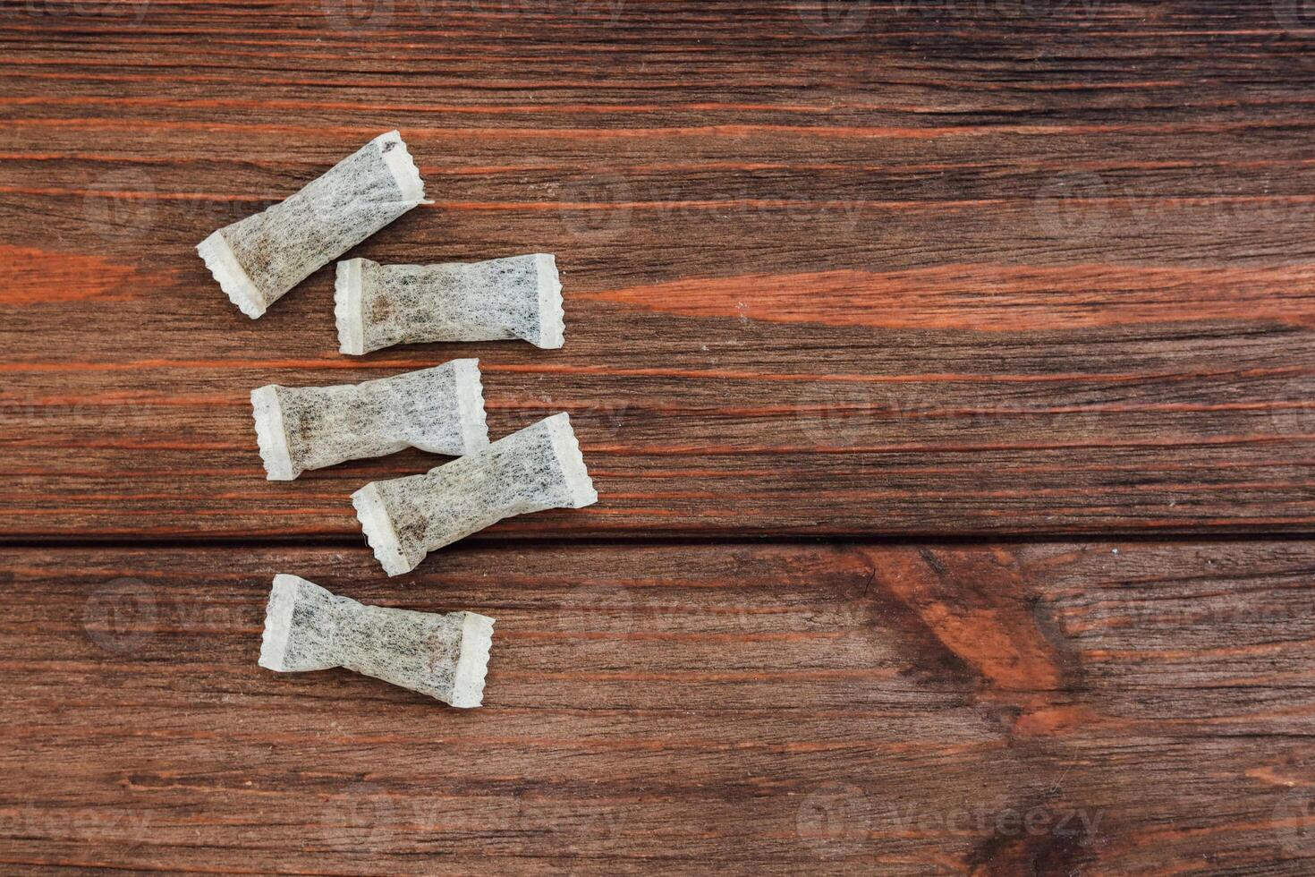 Nicotine snus pads, a smokeless alternative to cigarettes arranged on a wooden table showcasing a cozy tea moment at home in the afternoon photo