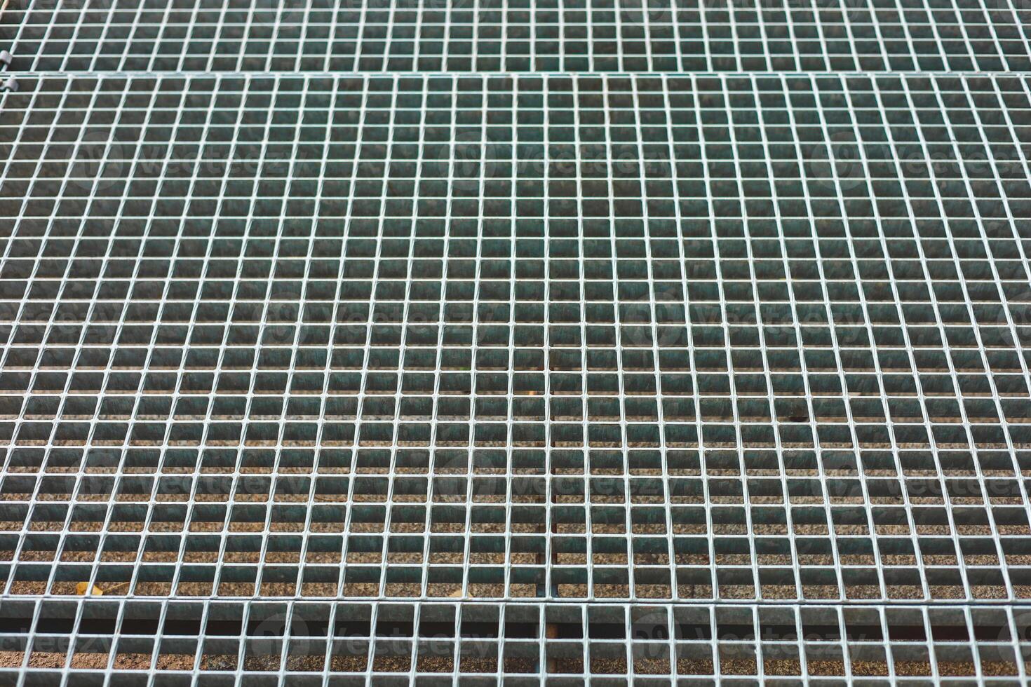 Metal grating surface with squares arranged in a pattern and detail of metallic texture photo
