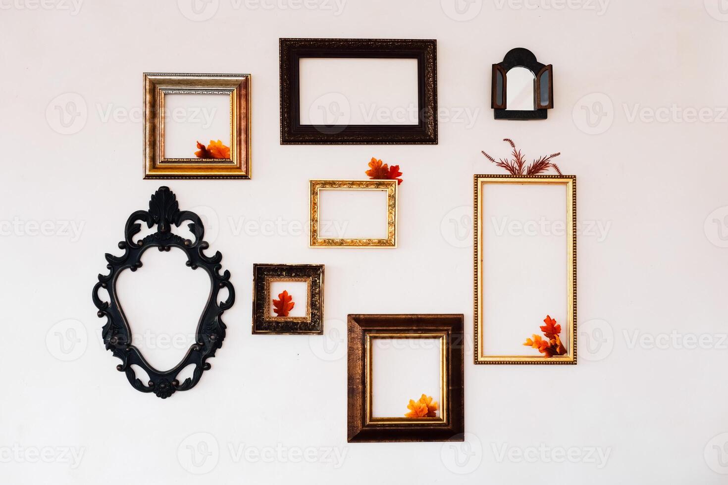 Wall display of empty frames with autumn leaves in a cozy interior setting photo