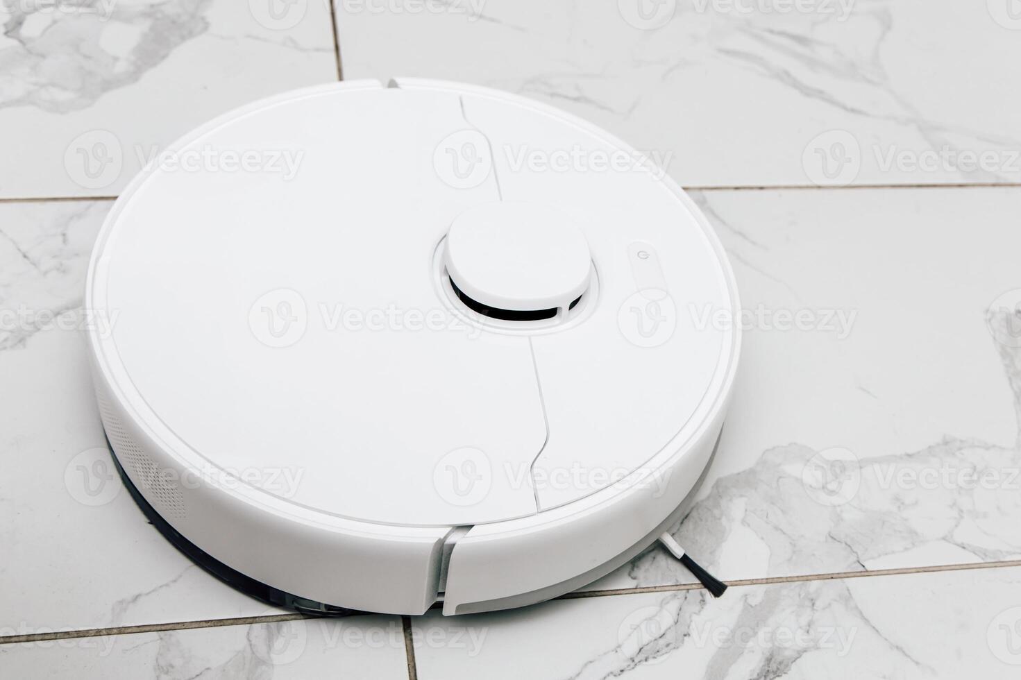 Robot vacuum cleaner operates on tiled floor during a bright afternoon in a modern home setting photo