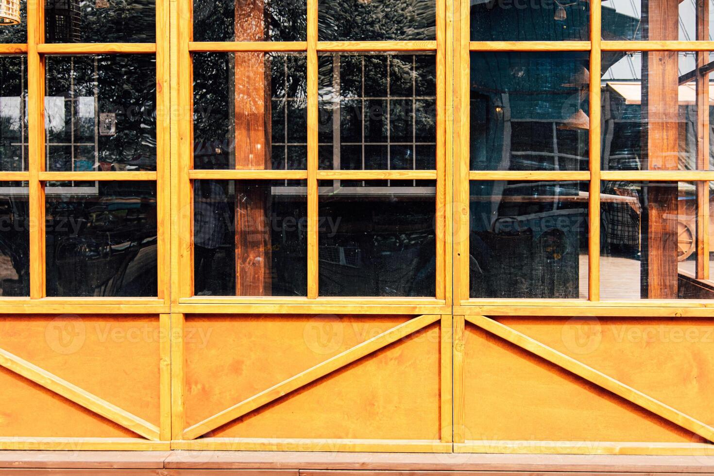 Bright yellow wooden window frames showcase the exterior of a rustic building in daylight photo