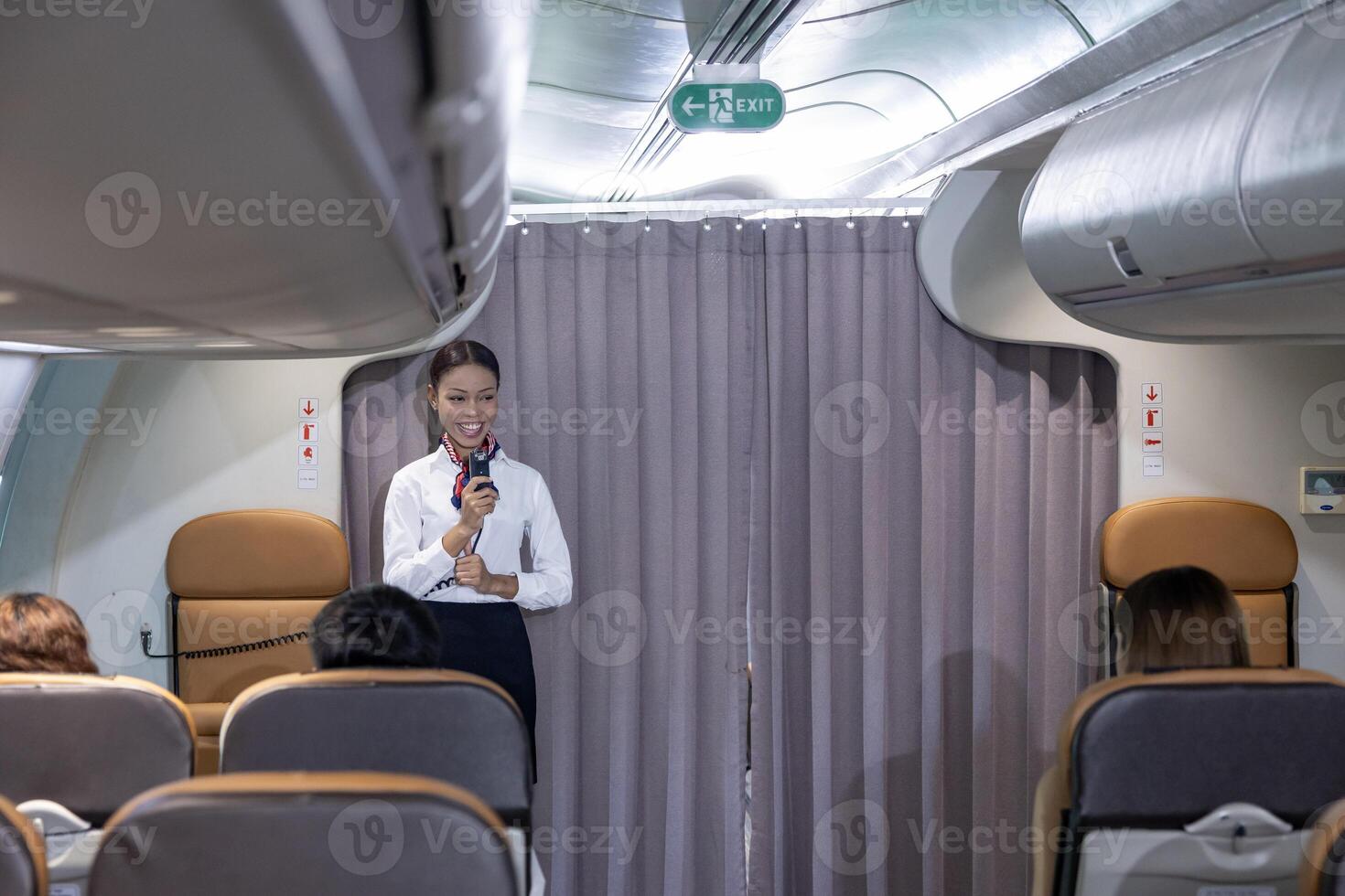 African flight attendant is greeting passenger to welcome on board to the flight and reporting the attitude, weather and route to the destination airport photo