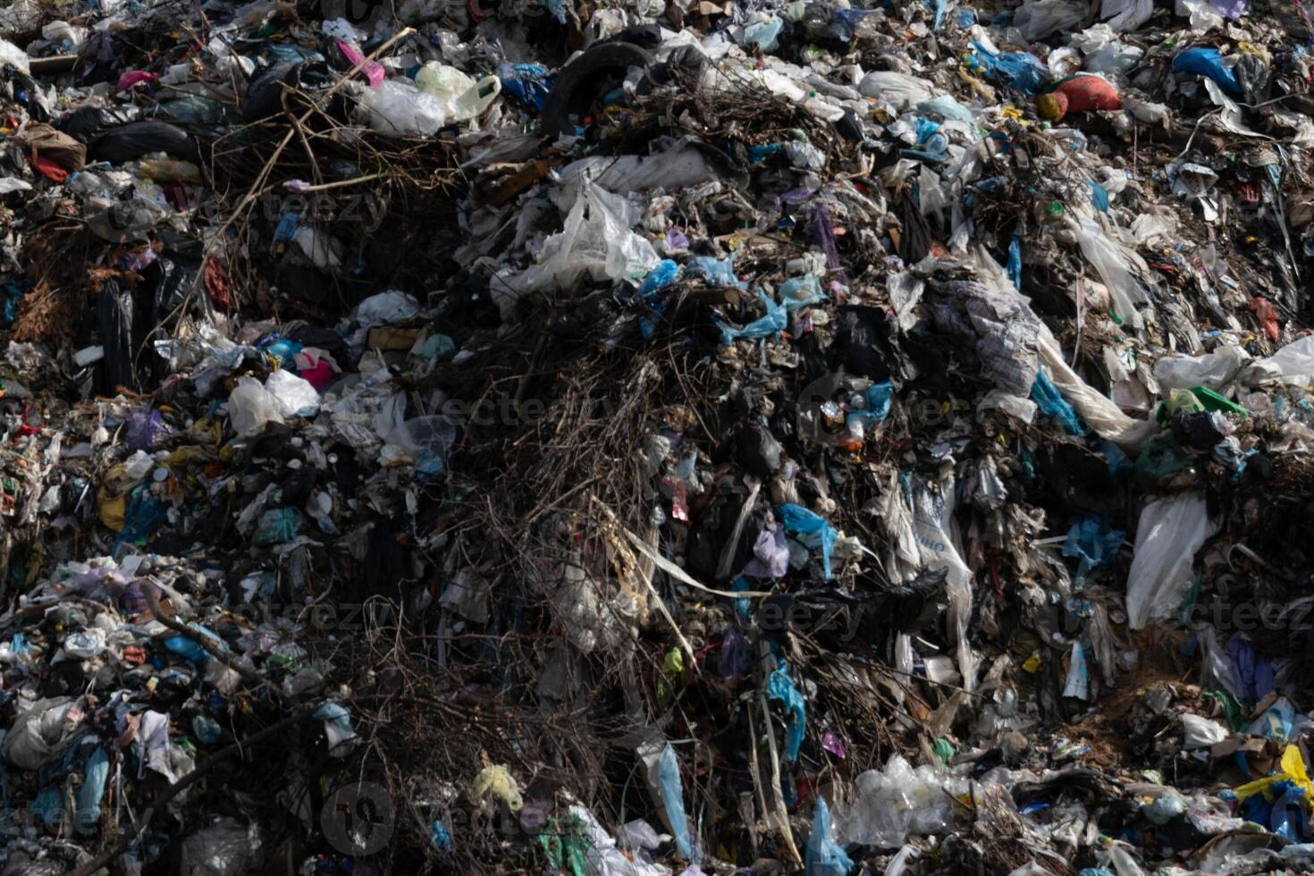 A sprawling mound of various types of waste dominates an urban landfill site, illustrating the significant environmental impact of human activities and waste management issues photo