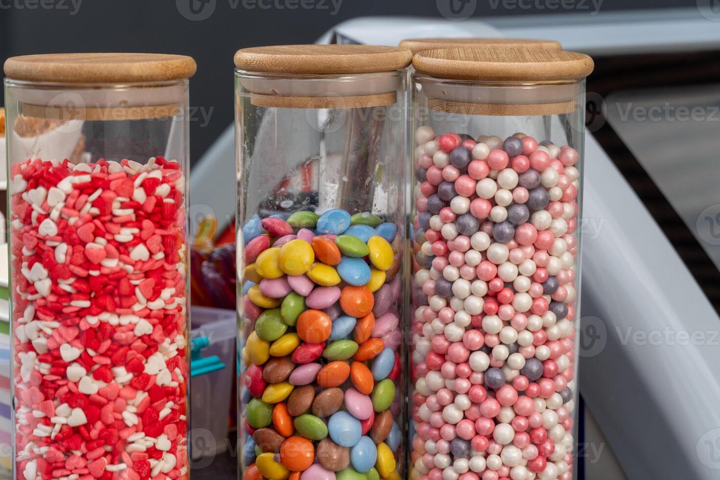 Brightly colored jars filled with assorted candies and sweets are showcased at a lively market, attracting visitors with their vibrant hues and enticing appearance photo