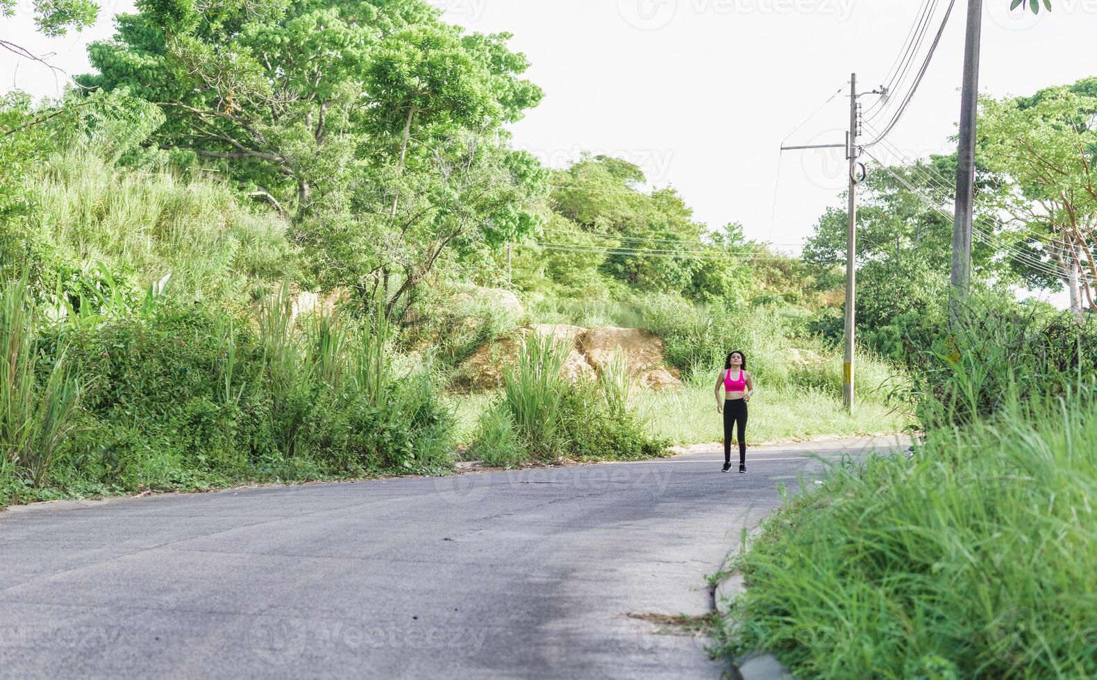 A woman running on a street young latin american woman wearing sportswear exercising photo