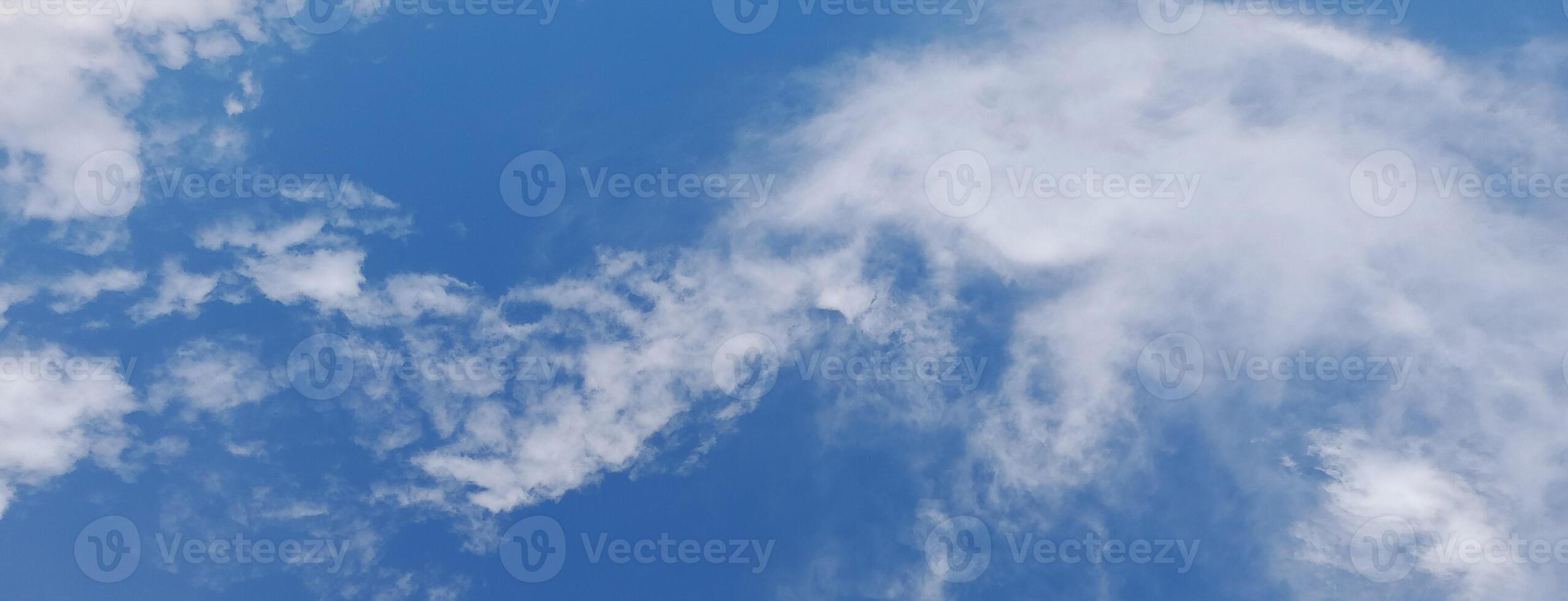 Bright blue sky with soft, wispy white clouds scattered across, creating a peaceful and airy atmosphere. photo