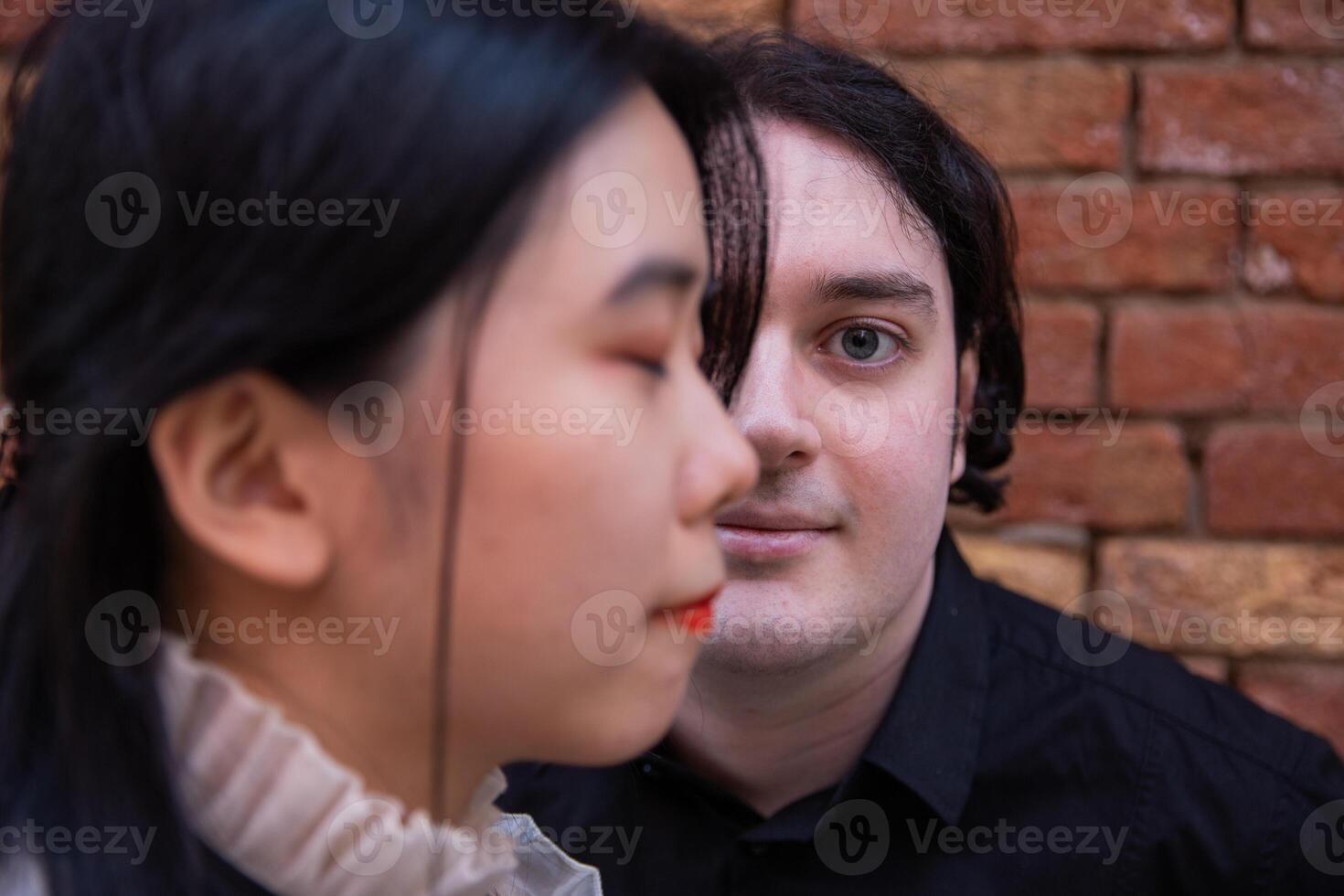 Portrait of caucasian boy with half face covered by an asian girl, concept of multiculturalism and union. photo